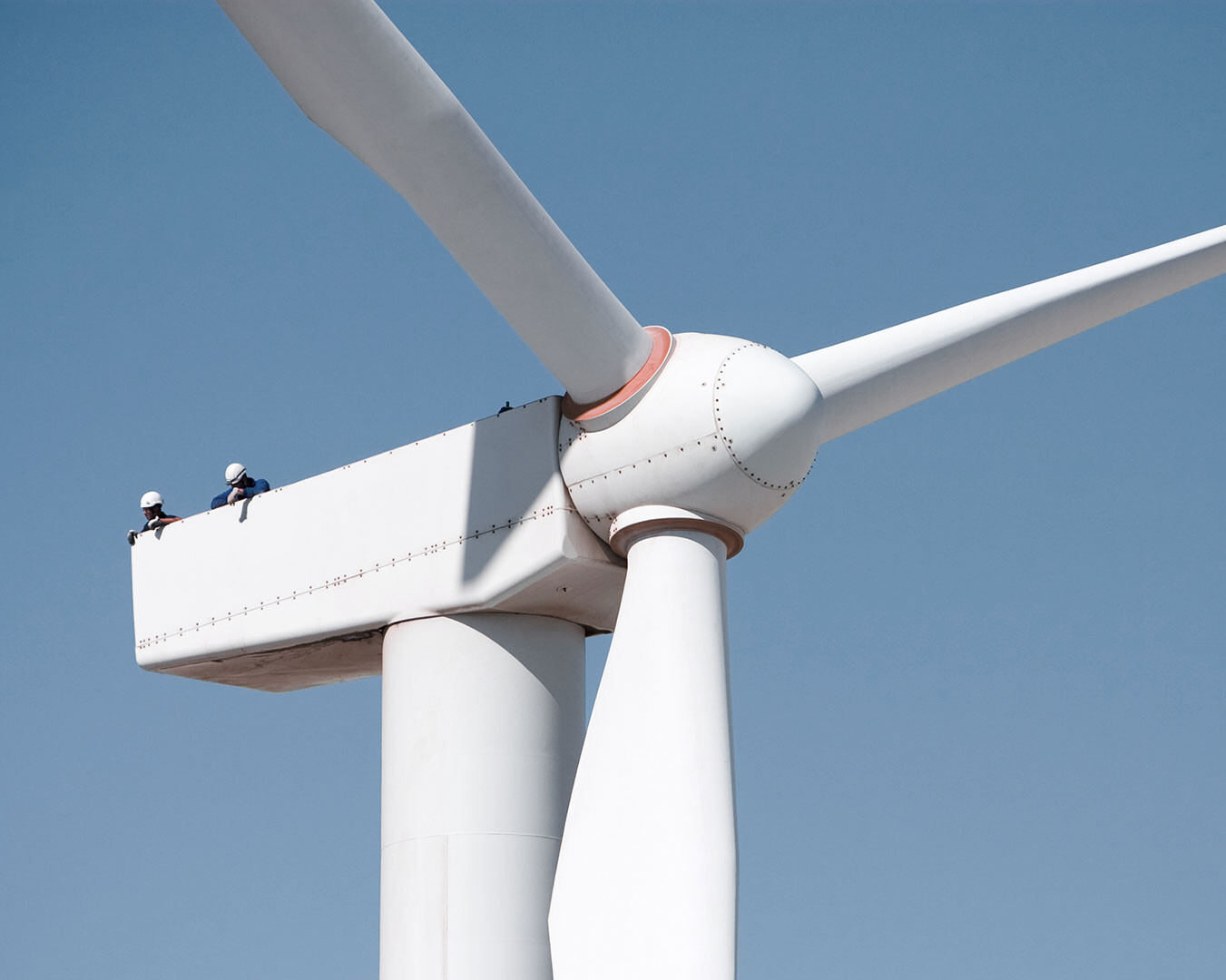 Raffinerie mit Meer im Vordergrund und Sonnenunaufgang im Hintergrund