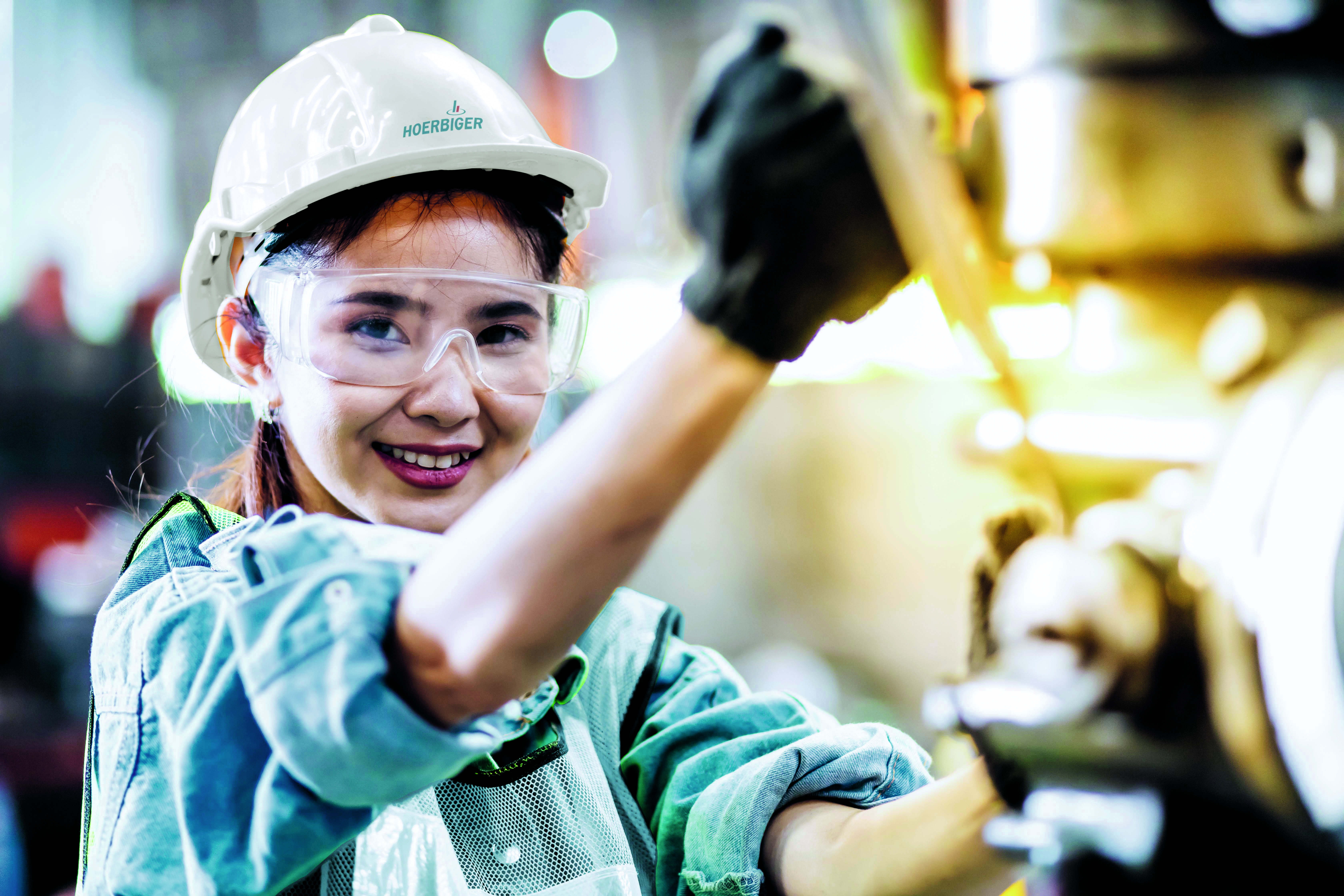 girl with hard hat at a machine girl with hard hat at a machine